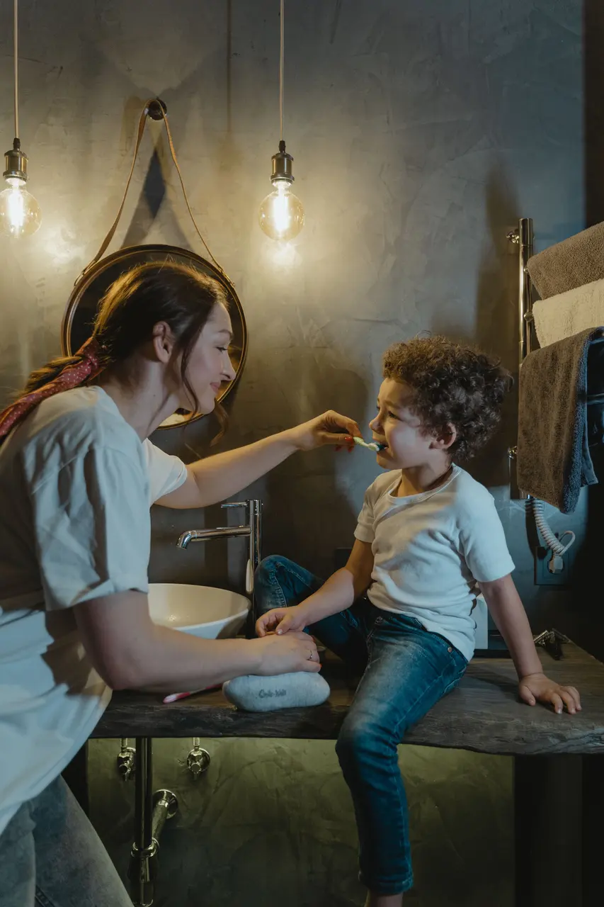 A parent and child smiling together in a mirror