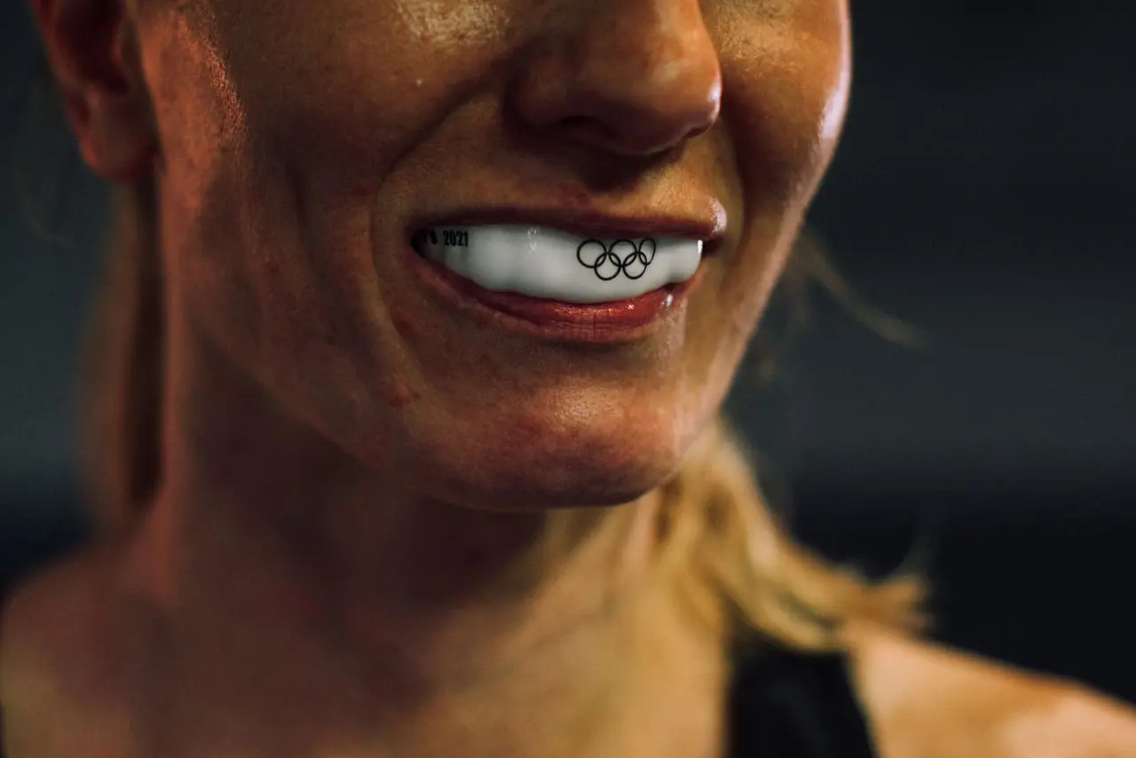 An athlete smiling while wearing a sports mouthguard